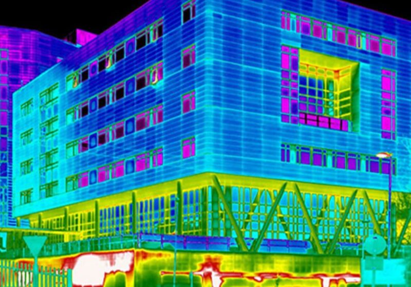 Vibrantly lit modern building glowing with neon colors at night.